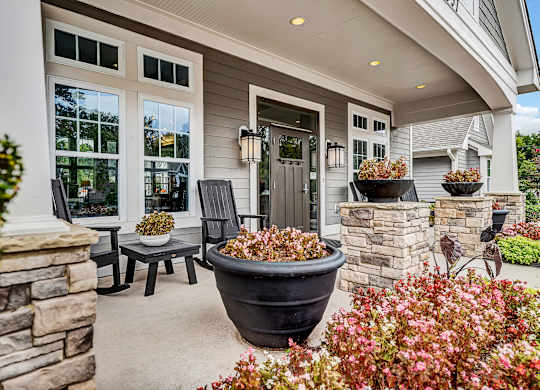 the front porch of a home with two chairs and a table and a large plant at Avellan Springs Apartments, North Carolina