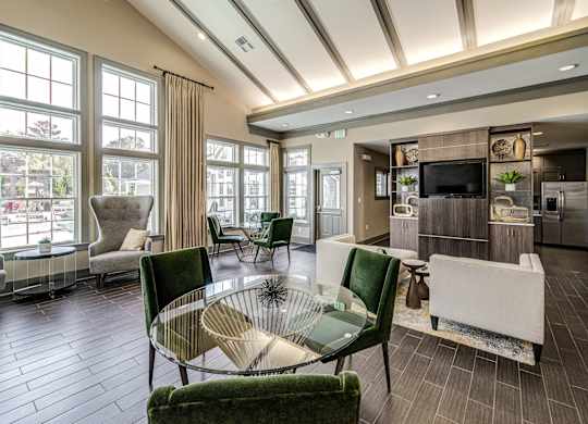 a living room with green chairs and a glass table at Avellan Springs Apartments, Morrisville, North Carolina