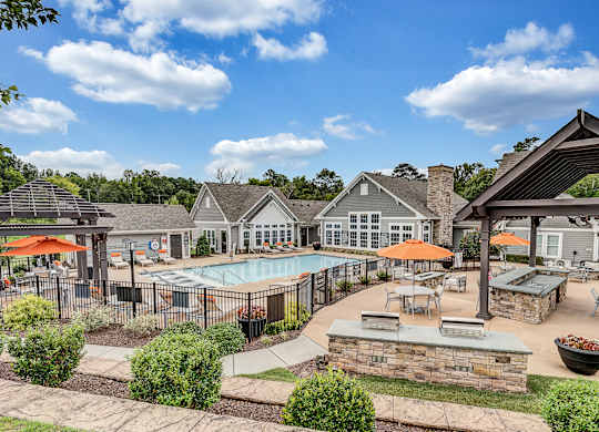 an outdoor pool with tables  at Avellan Springs Apartments, Morrisville