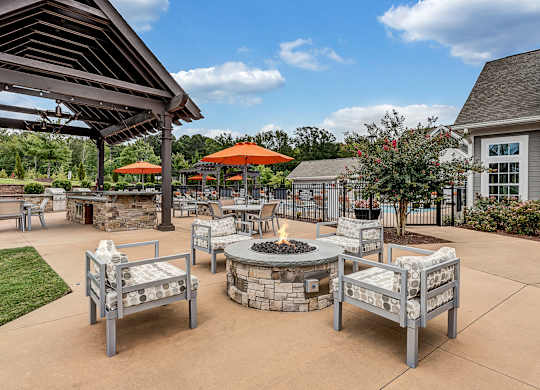 an outdoor patio with a fire pit and tables at Avellan Springs Apartments, Morrisville, North Carolina