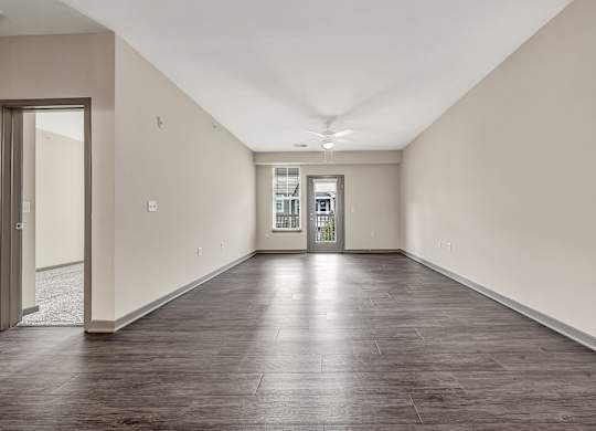 an empty living room with white walls and wood floors at Avellan Springs Apartments, Morrisville, North Carolina