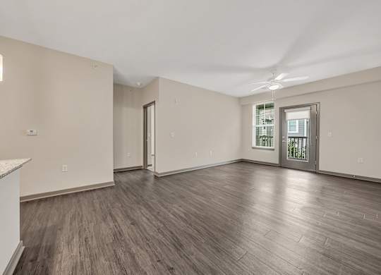 the living room of an empty home with wood flooring and a door to a at Avellan Springs Apartments, Morrisville, North Carolina