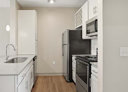 A kitchen with white cabinets and black appliances.