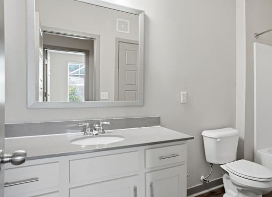 A white bathroom with a sink, toilet, and bathtub.