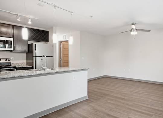 A kitchen with a counter and a fan on the ceiling.