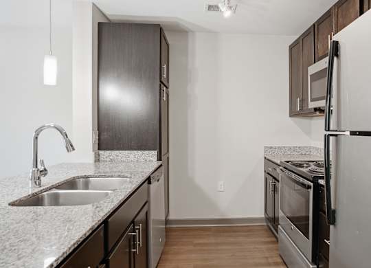 A kitchen with a sink and a refrigerator.