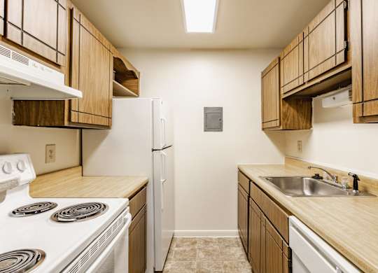 A kitchen with wooden cabinets and a white stove top oven