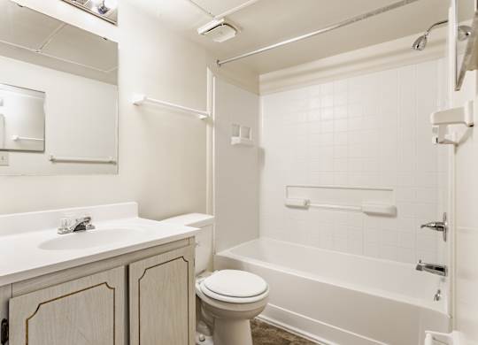 A white bathroom with a toilet, sink, and bathtub