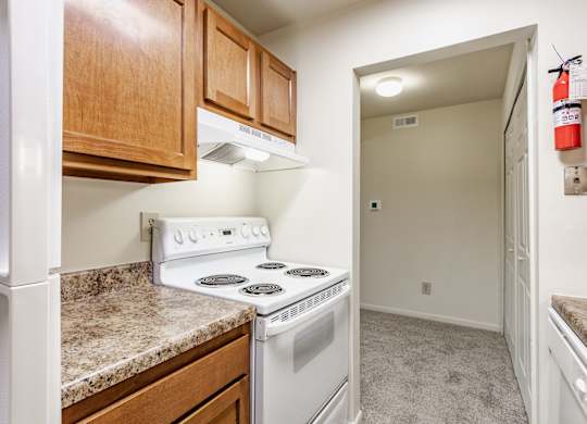 A kitchen with a white stove and wooden cabinets