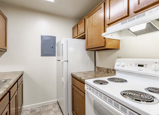 A kitchen with a white stove and a white refrigerator
