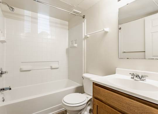 A white bathroom with a toilet, sink, and bathtub