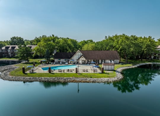a backyard with a pool and a house next to a lake