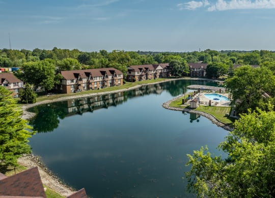 an aerial view of a lake with apartments in the background