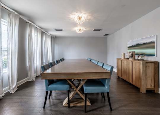 A dining room with a wooden table and blue chairs.