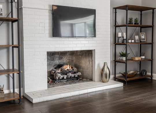 A modern living room with a fireplace and a flat screen TV mounted above it.