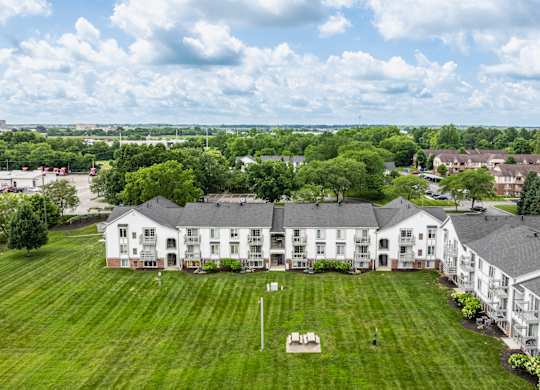 A large white building with a green lawn in front.