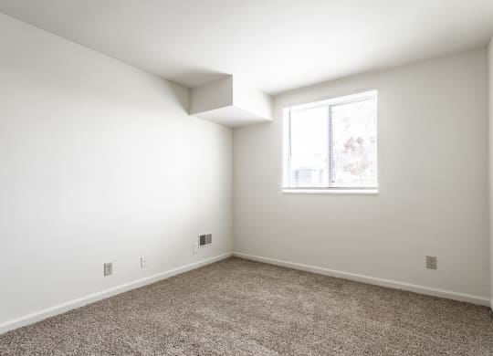 an empty room with white walls and a window at Bay Pointe Apartments in Lafayette, IN
