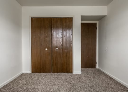 a bedroom with two closet doors and a carpet floor at Bay Pointe Apartments in Lafayette, IN 47909