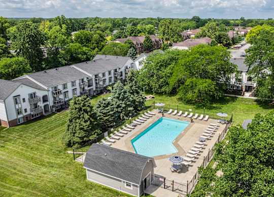 An aerial view of a resort with a swimming pool and lounge chairs.