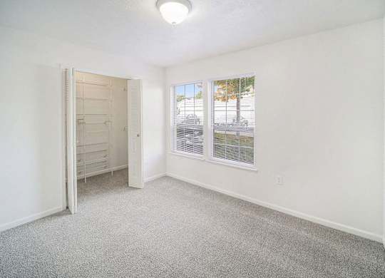 an upgraded bedroom with a walk in closet and a window at Black Sand Apartment Homes in Lincoln, NE
