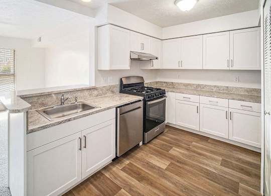 an upgraded kitchen with white cabinets and stainless steel appliances at Black Sand Apartment Homes in Lincoln, NE