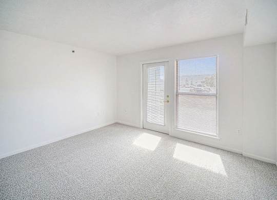 the living room with a door to a patio at Black Sand Apartment Homes in Lincoln, NE