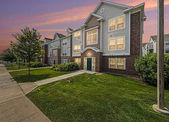 Three story apartment building at sunset with illuminated windows at Black Sand Apartments Homes, Nebraska, 68504