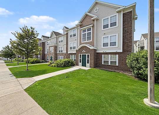 Apartment building exterior with manicured lawn and walkway at Black Sand Apartments Homes, Lincoln, NE 68504