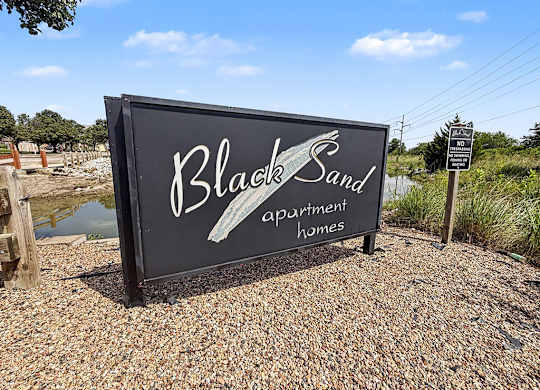 Property entrance sign with decorative wave design at Black Sand Apartments Homes, Lincoln