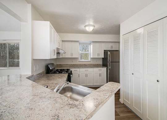 A kitchen with white cabinets and a stainless steel appliances at Brentwood Park Apartments, La Vista, Nebraska