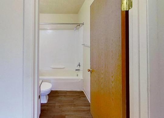 A bathroom with a toilet, tub, and sink at Briarwood Apartments in Benton Harbor, MI