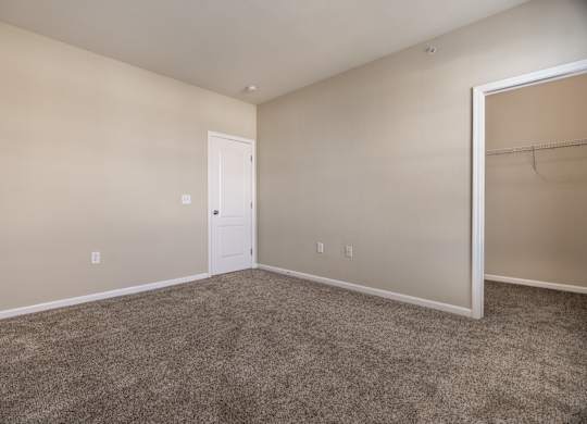 A room with a carpeted floor and a white door