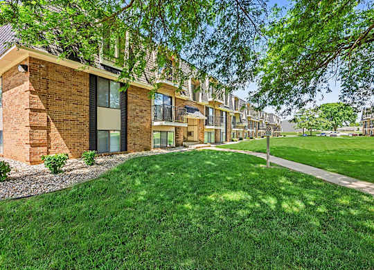 A row of houses with green lawns in front.