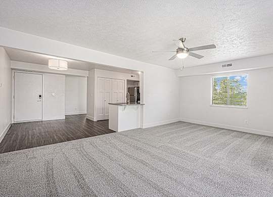 A spacious room with a ceiling fan and carpeted floor at Byron Lakes Apartments in Byron Center, MI