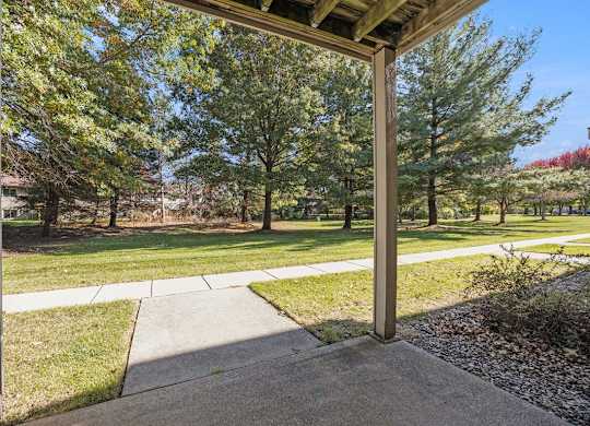 a private patio overlooking park like grounds with trees  at Byron Lakes Apartments, Byron Center, MI, 49315