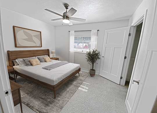 A bedroom with a bed, a ceiling fan, and a rug at Byron Lakes Apartments, Michigan, 49315