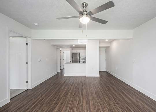 A living room with a ceiling fan and hard surface flooring at Byron Lakes Apartments in Byron Center, MI