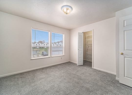 Bedroom with Large Closet and Multiple Windows at Canal 2 Apartments in Lansing, MI