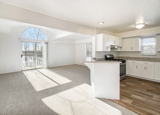 an open end style kitchen and living room with a door to a balcony at Canal 2 Apartments, Lansing, Michigan