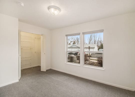 Bedroom with two large windows and a walk in closet at Canal 2 Apartments, Lansing, Michigan