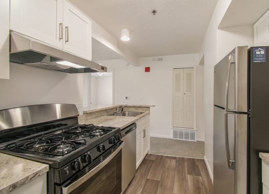 a kitchen with stainless steel appliances and white cabinets at Canal 2 Apartments, Lansing, Michigan