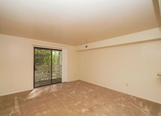 Living Room Leads to Balcony at Canal Club Apartments in Lansing, MI