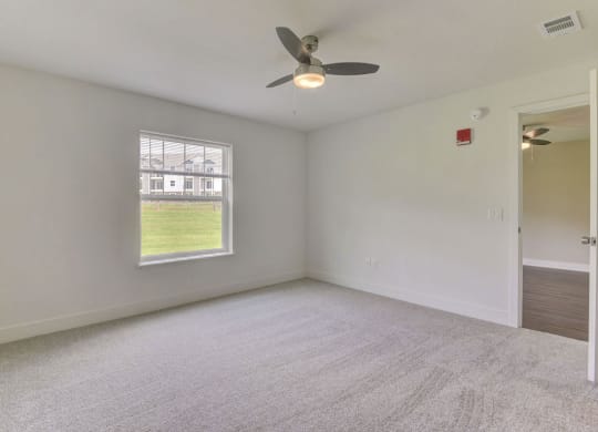 an empty room with a ceiling fan and a window at Chase Creek Apartment Homes, Alabama