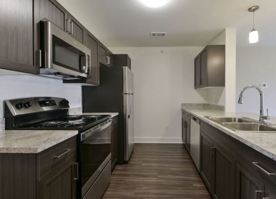 a kitchen with dark wood cabinets and white countertopsat Chase Creek Apartment Homes in Huntsville, AL