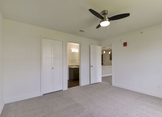 a room with a ceiling fan and a door to a bathroom at Chase Creek Apartment Homes, Huntsville, AL