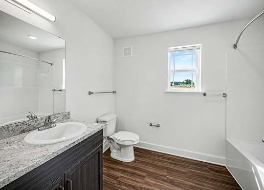 A bathroom with a toilet, sink, and bathtub.