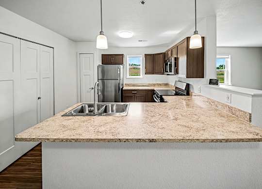 A kitchen with a granite countertop and white cabinets.
