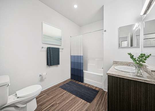 A bathroom with a toilet, sink, and mirror at Chase Creek Apartment Homes, Huntsville, AL, 35811