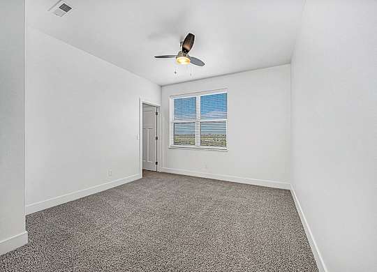 A bedroom with a ceiling fan and a window with blinds at Chase Creek Apartment Homes, Huntsville, AL, 35811