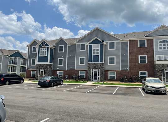 An exterior building with a parking lot in front at Chase Creek Apartment Homes, Huntsville, 35811